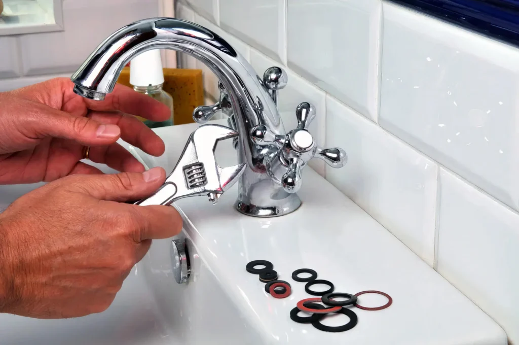 Plumber performing maintenance on a bathroom faucet in Oregon City