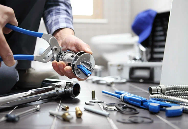 Technician repairing a plumbing fixture with professional tools in Oregon City