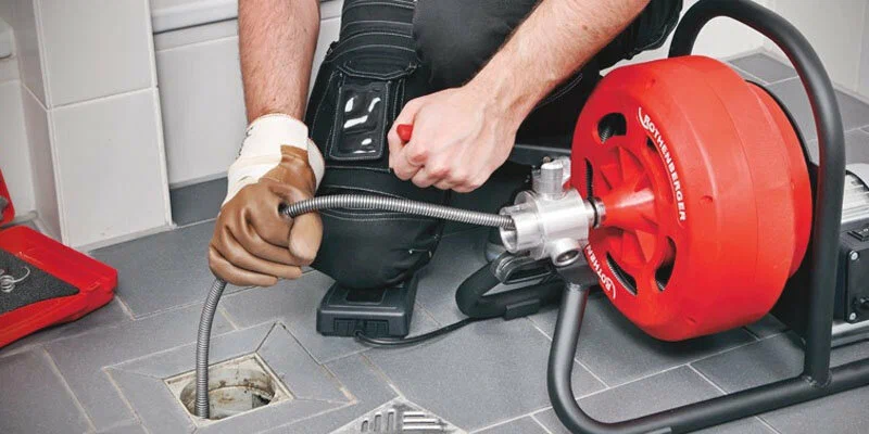 Plumber using a drain-cleaning machine in Oregon City