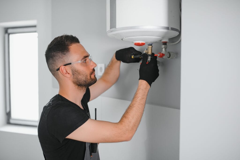Technician performing water heater maintenance in Oregon City